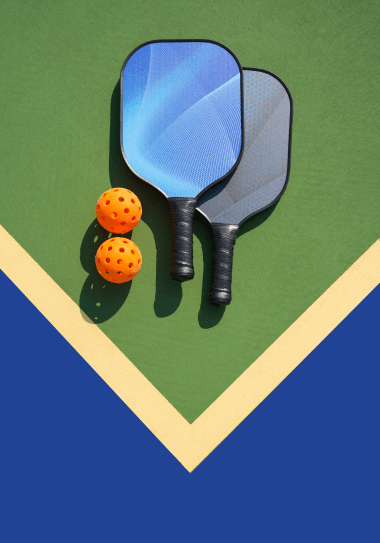 Pickelball paddles and balls on court